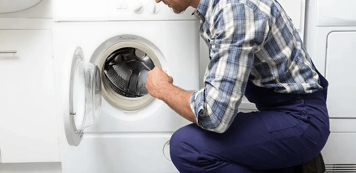 Handyman inspecting a dryer drum and internal parts for repair in Cape Coral, FL
